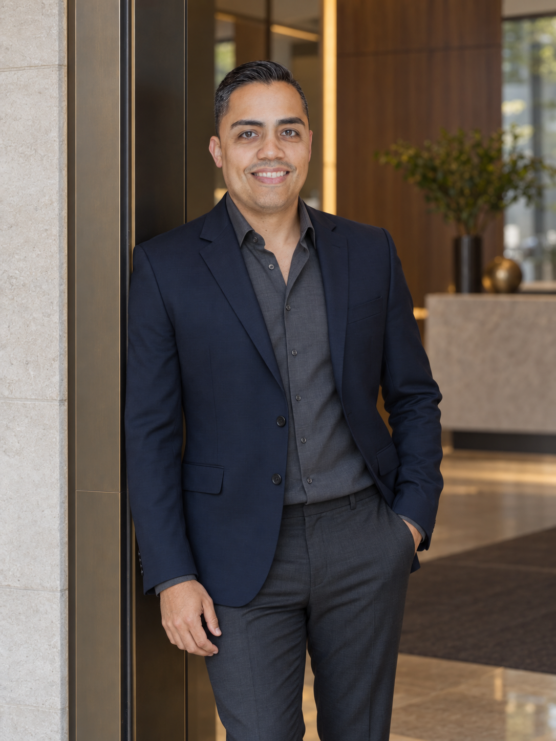 Eric in a navy blazer at a modern office entrance